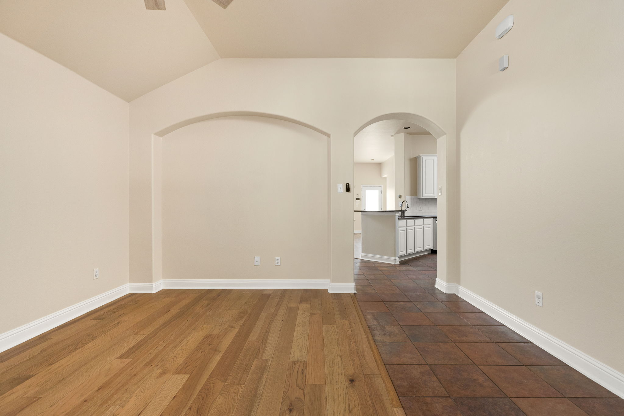 784 Sampson Kyle, TX 78640 - Photo 8 of 40 Hardwood floors and graceful arched entries connect the living space to the kitchen.