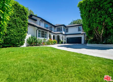 a front view of a house with yard and potted plants