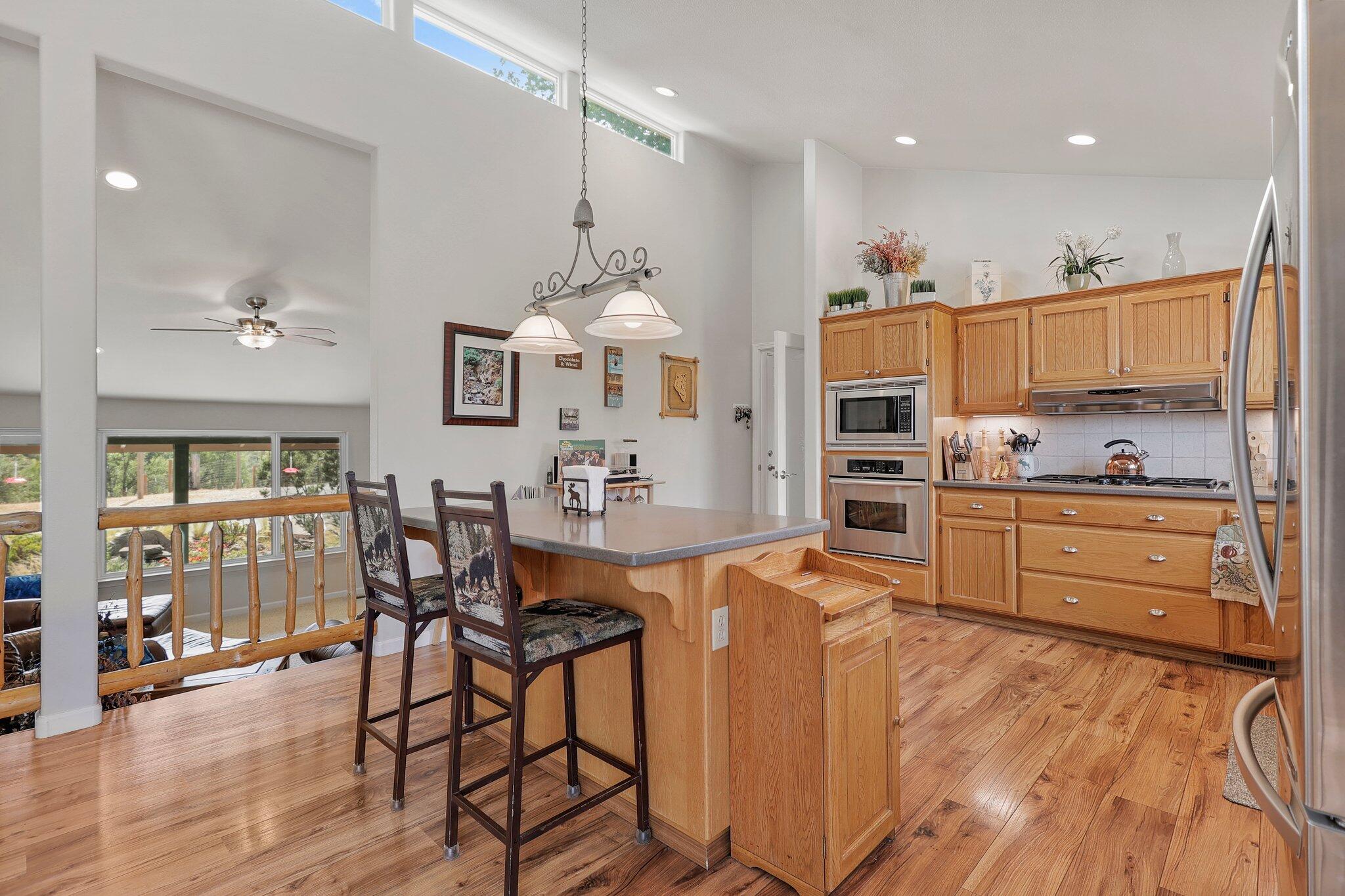 6949 Rector Creek Road Igo, CA 96047 - Photo 15 of 110 a kitchen with stainless steel appliances kitchen island granite countertop a table chairs and a refrigerator