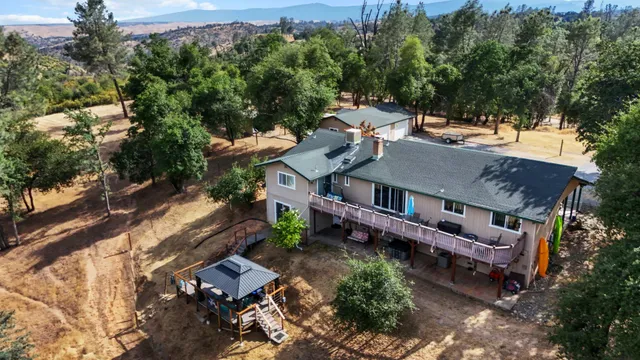 an aerial view of green landscape with trees houses and mountain view