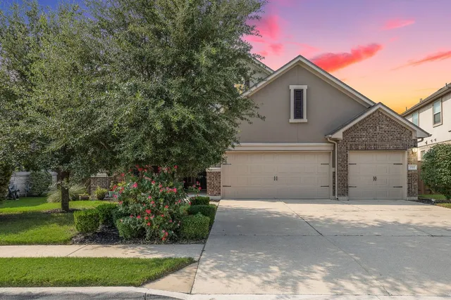 a front view of a house with a yard and a garage