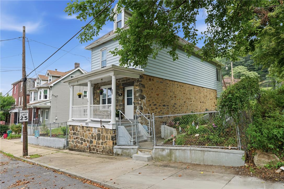 A stone and siding facade creates a welcoming street presence with its front porch.