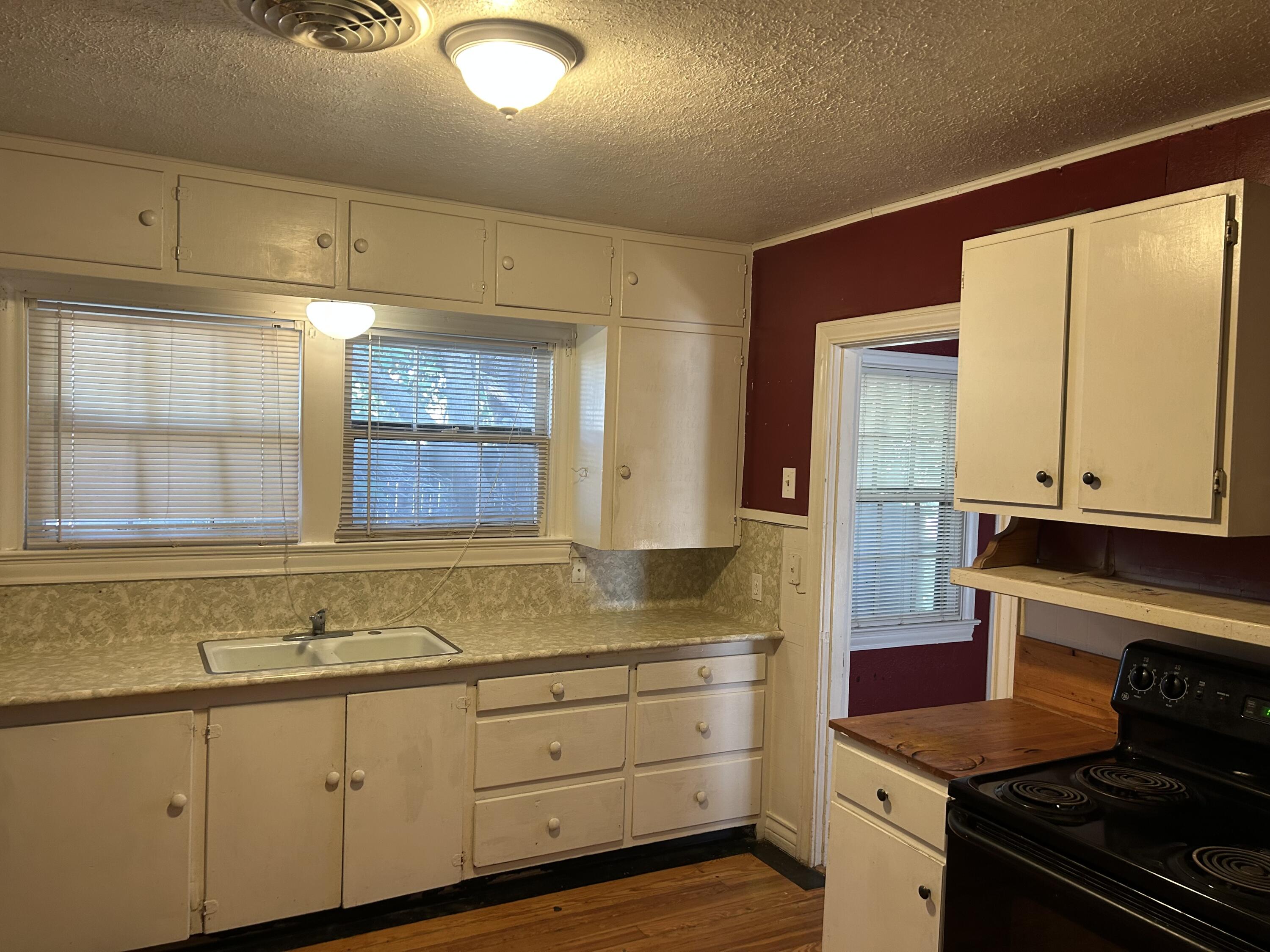 2011 31st Street Lubbock, TX 79411 - Photo 4 of 10 a kitchen with granite countertop white cabinets and window