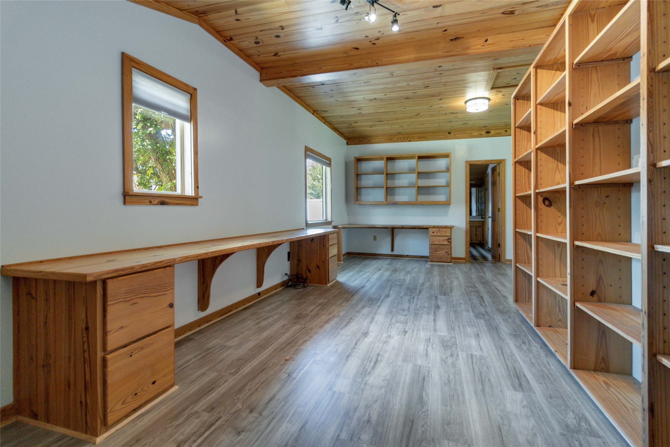 180 Ironstone Road Smithville, TX 78957 - Photo 25 of 37 Unfurnished office featuring built in desk, a vaulted wooden ceiling, light wood-style floors, and track lighting