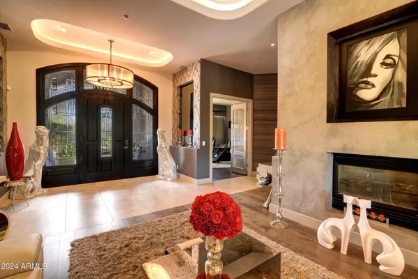 a living room with furniture a fireplace and a chandelier