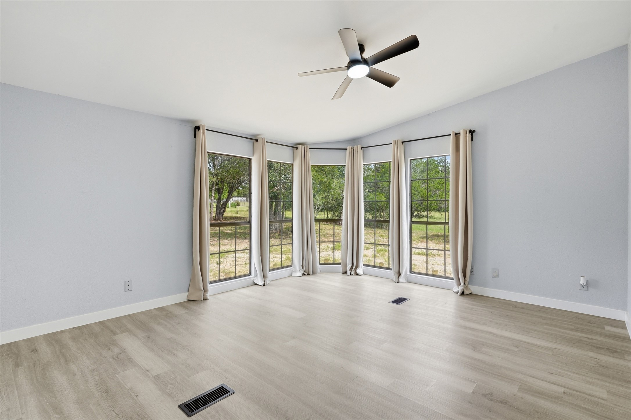 154 Antioch Road Smithville, TX 78957 - Photo 14 of 32 A spacious room with bay windows provides abundant natural light and scenic outdoor views.