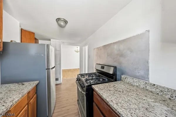 a kitchen with a refrigerator and a stove top oven