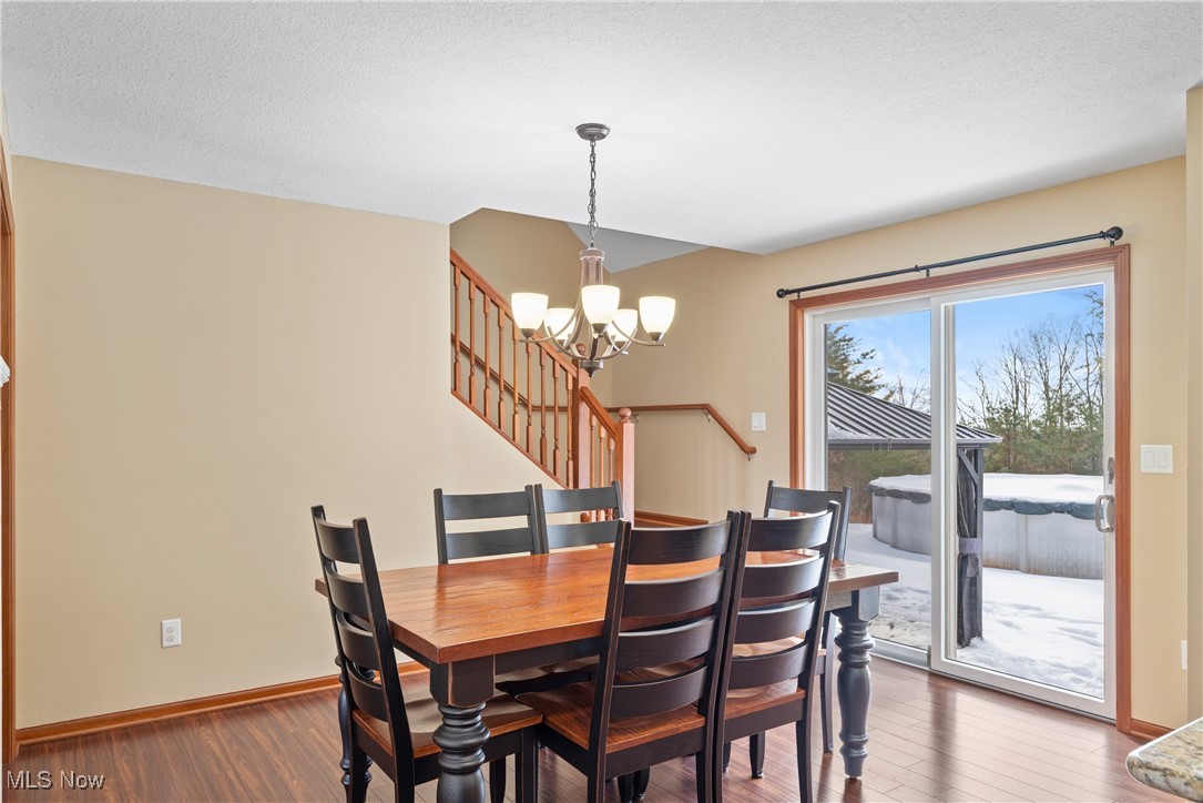 399 Wilder Road Vinton, OH 45686 - Photo 11 of 36 Dining room with a chandelier, wood-type flooring, and a textured ceiling