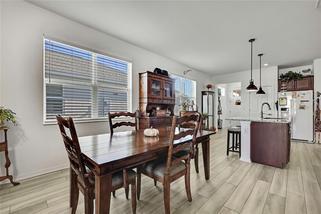 9764 Southwest 100th Avenue Ocala, FL 34481 - Photo 12 of 37 a view of a dining room with furniture and wooden floor