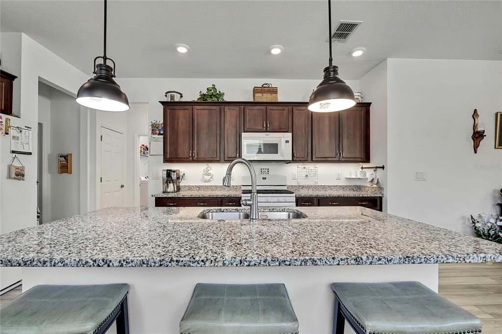 9764 Southwest 100th Avenue Ocala, FL 34481 - Photo 15 of 37 a kitchen with stainless steel appliances granite countertop a sink a stove and a refrigerator
