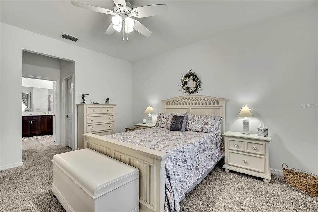 9764 Southwest 100th Avenue Ocala, FL 34481 - Photo 18 of 37 a bedroom with a bed and a chandelier