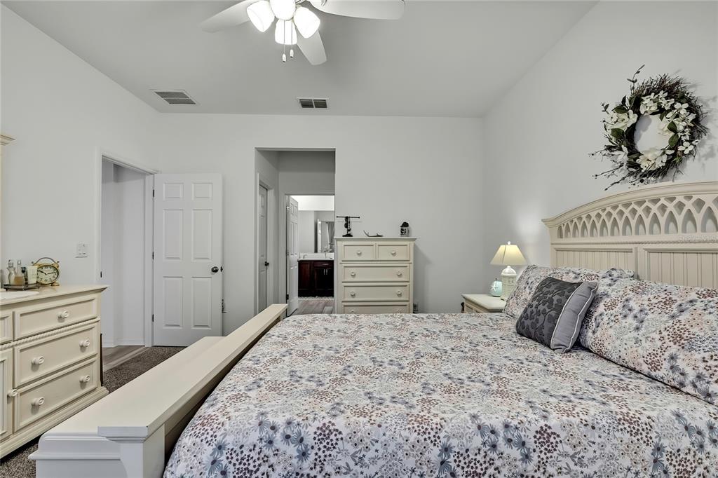 9764 Southwest 100th Avenue Ocala, FL 34481 - Photo 19 of 37 a bedroom with a bed and a chandelier