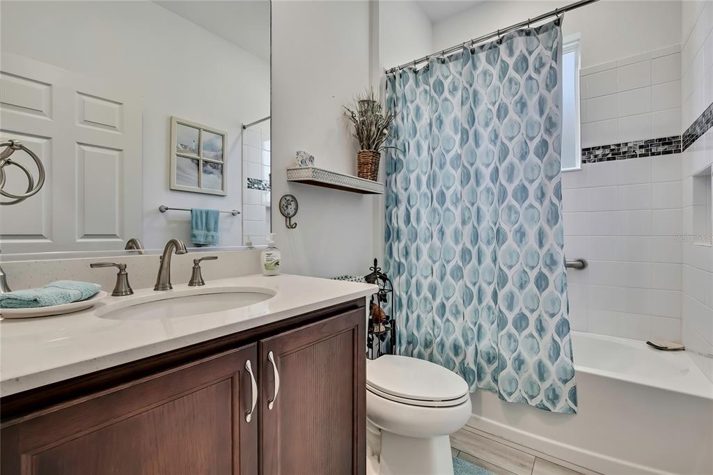 9764 Southwest 100th Avenue Ocala, FL 34481 - Photo 25 of 37 a bathroom with a granite countertop sink a toilet and a mirror