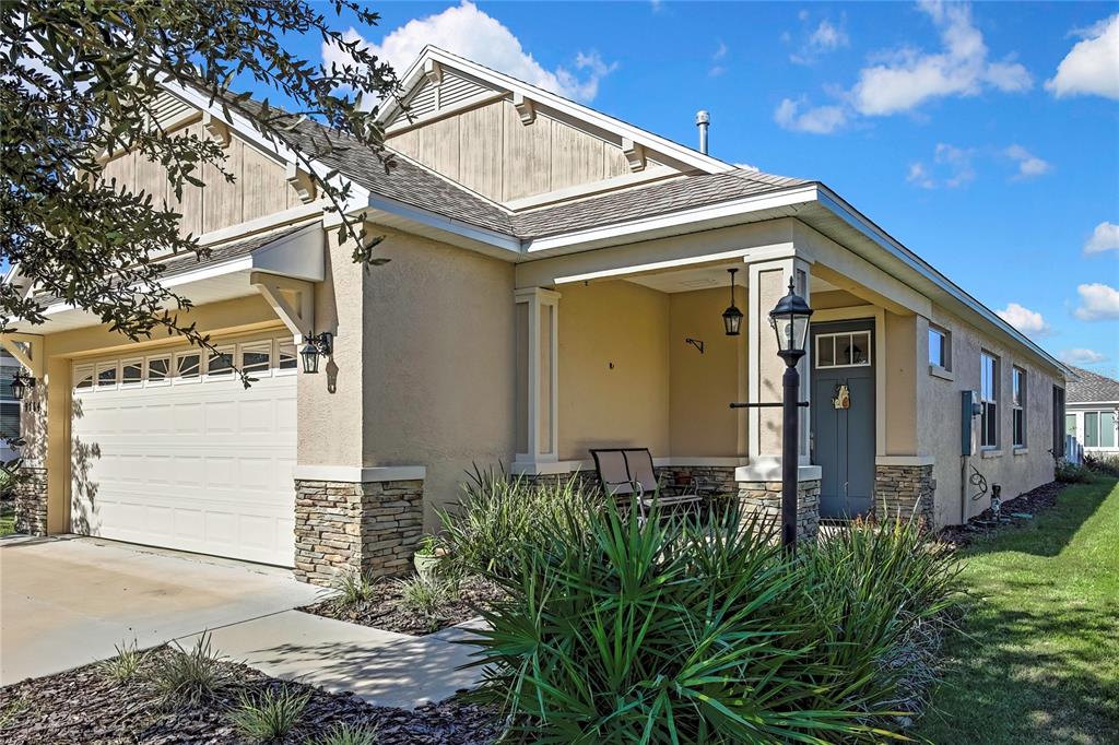 9764 Southwest 100th Avenue Ocala, FL 34481 - Photo 3 of 37 a view of a house with a small yard plants and large tree