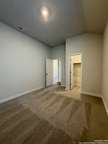 an empty room with closet and mirrors