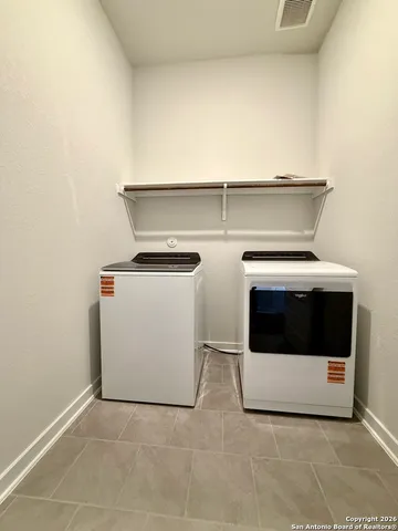 an empty room with wooden floor ceiling fan and windows