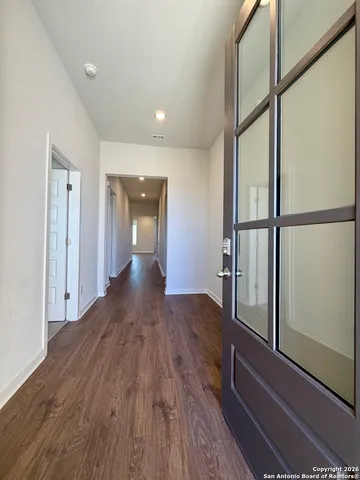 a view of a hallway with wooden floor and staircase