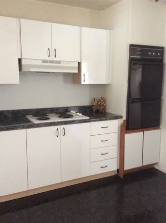 a kitchen with granite countertop white cabinets and white appliances
