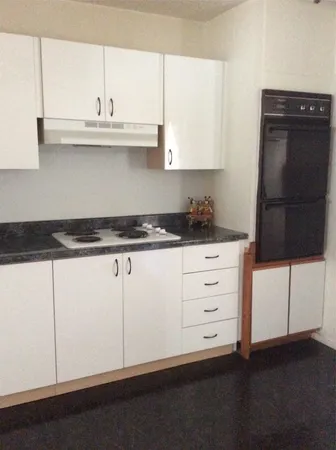 a kitchen with white cabinets and sink