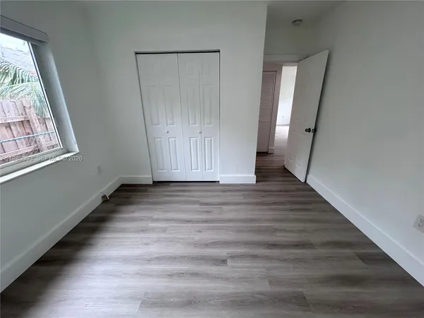 a view of a hallway with wooden floor and entryway
