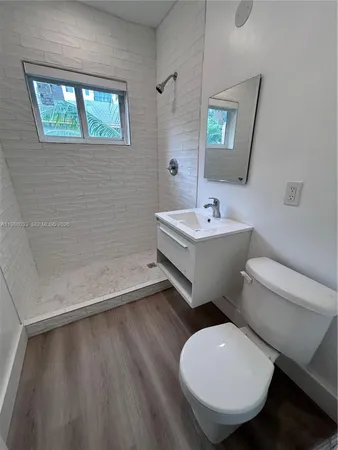 a bathroom with a toilet sink and mirror