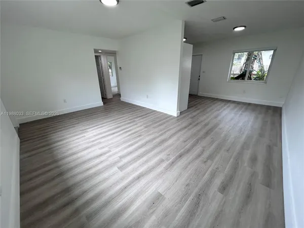 wooden floor in an empty room with a window