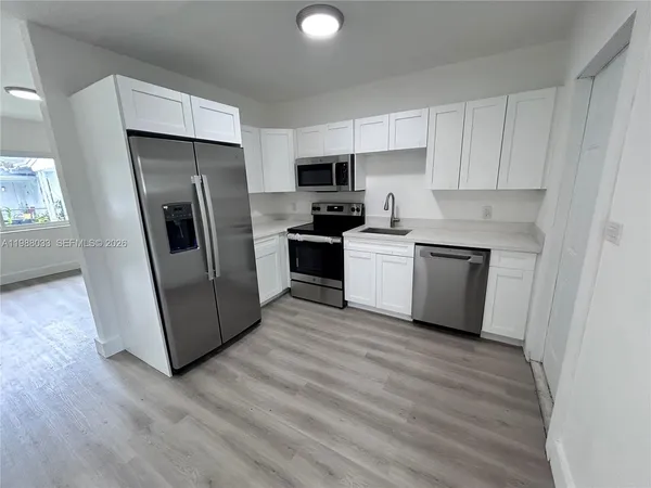a kitchen with stainless steel appliances a refrigerator and a stove top oven