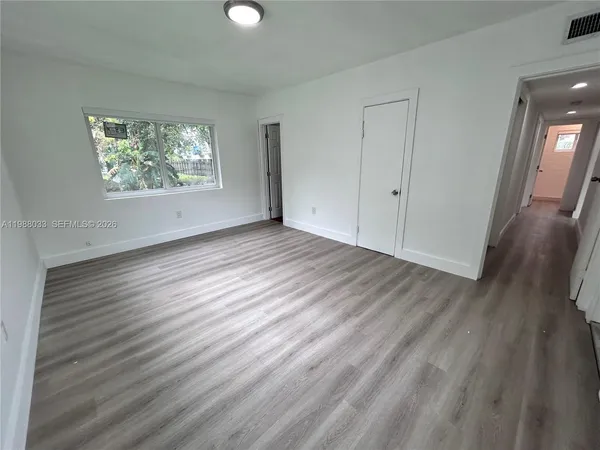 wooden floor in an empty room with a window