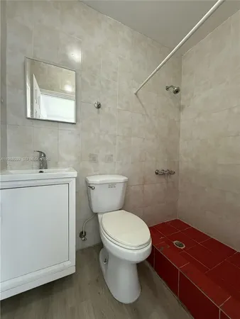 a bathroom with a toilet sink and mirror