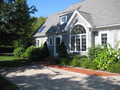 130 Parker Road, Unit B Osterville, MA 02655 - Photo 1 of 13 a view of a white house with a yard and potted plants