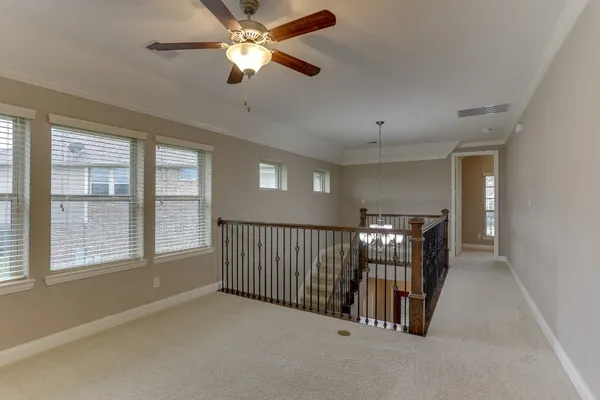 an empty room with a window and a fan