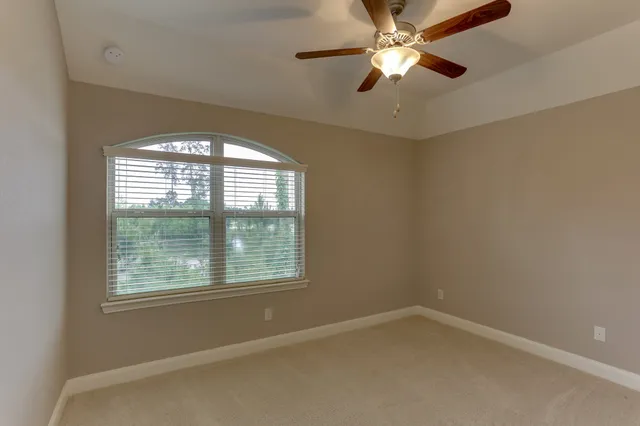 an empty room with a window and a fan