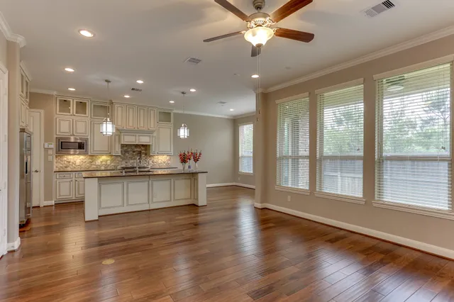 a large kitchen with stainless steel appliances granite countertop a stove and a large window