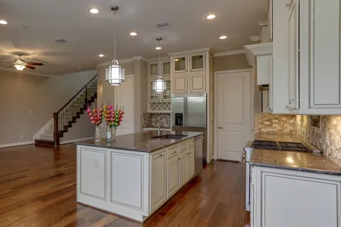 a kitchen with stainless steel appliances kitchen island granite countertop a refrigerator and a stove top oven