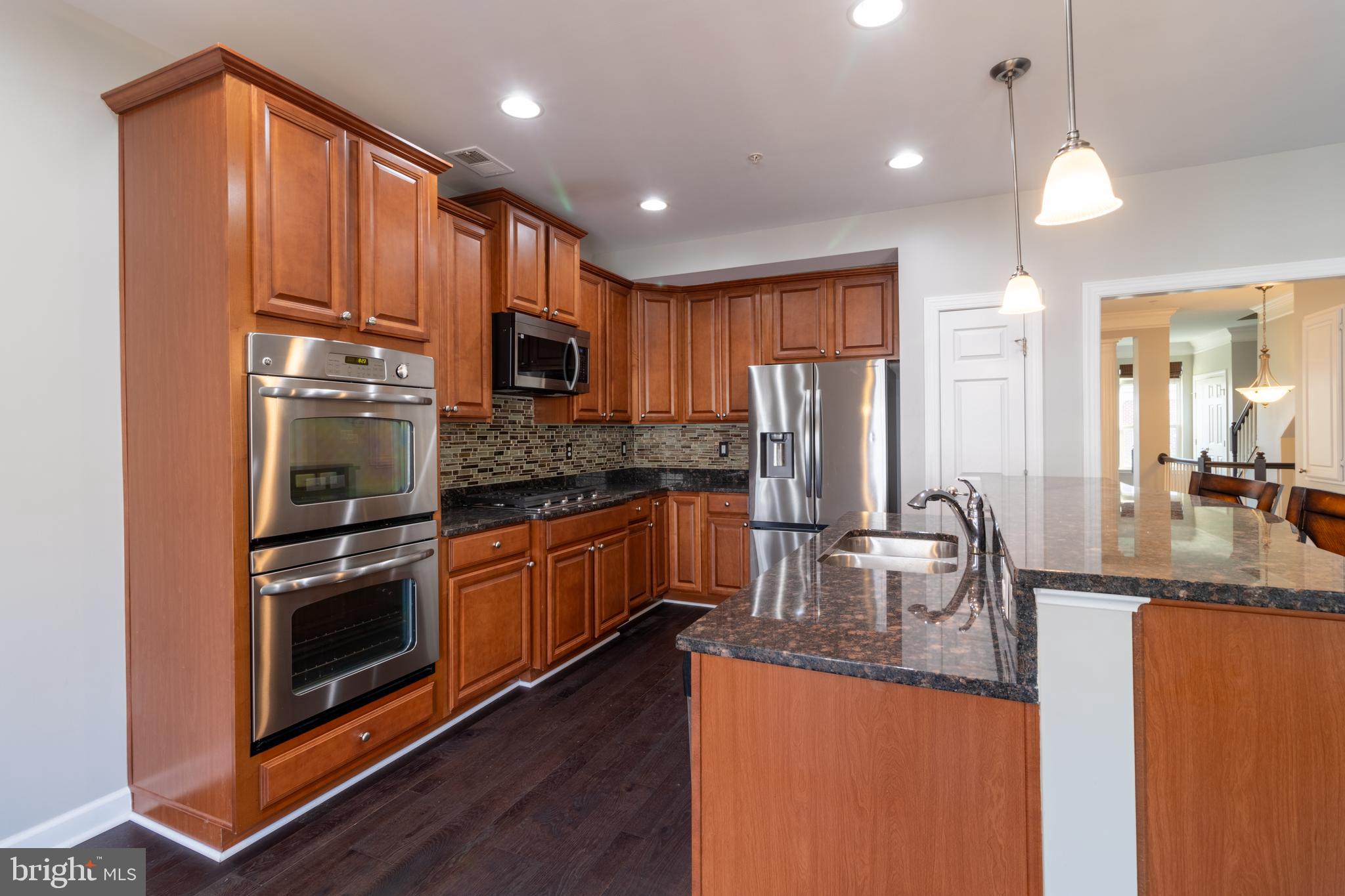 a kitchen with stainless steel appliances granite countertop a refrigerator a stove top oven a sink and dishwasher