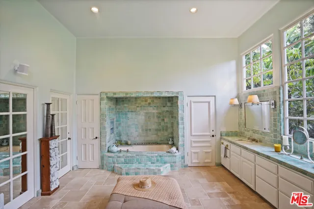 a spacious bathroom with a granite countertop sink mirror and bathtub
