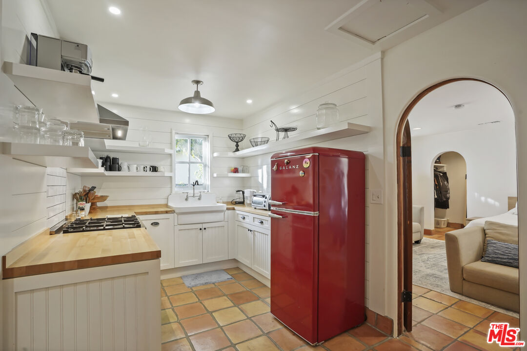 7332 Birdview Avenue Malibu, CA 90265 - Photo 40 of 71 a kitchen with stainless steel appliances granite countertop a stove a refrigerator and a sink