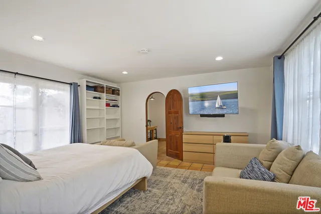 a bedroom with a large bed and a mirror