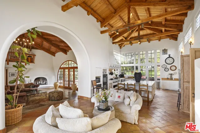 a view of a patio with couches and table and chairs and potted plants