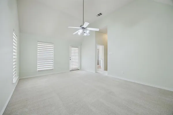 an empty room with windows and fan
