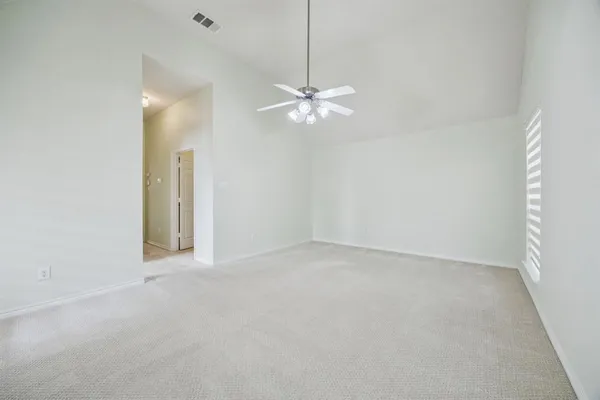 an empty room with a window and a fan