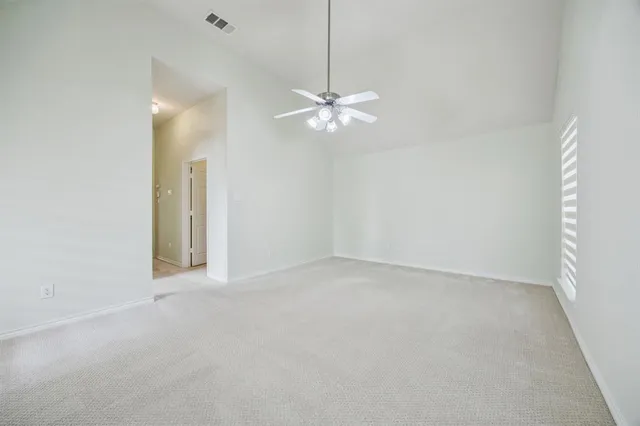an empty room with a window and a fan