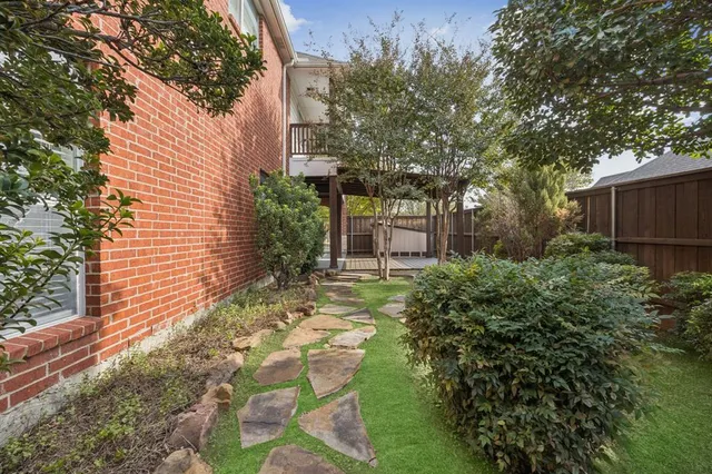 a backyard of a house with table and chairs and potted plants