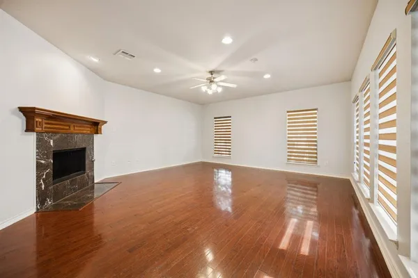 a view of an empty room with a fireplace and a window