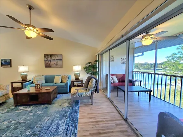 a living room with furniture a window and wooden floor
