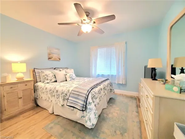 a spacious bedroom with a bed and a chandelier