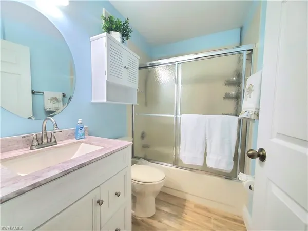 a bathroom with a granite countertop sink toilet a mirror and shower