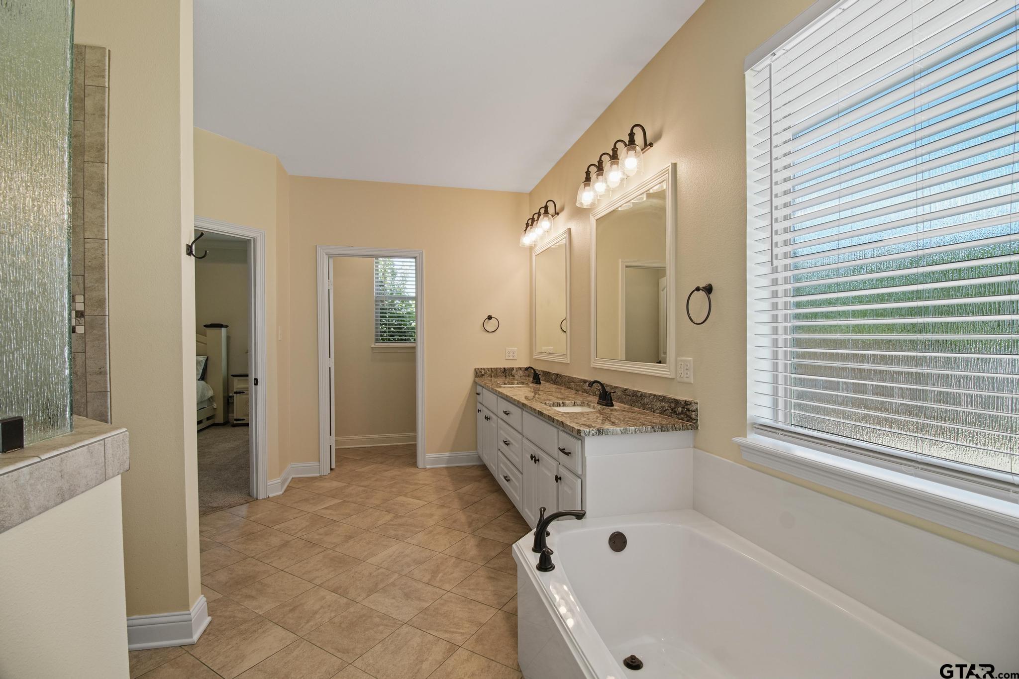 109 Nathan Road Chandler, TX 75758 - Photo 18 of 48 a spacious bathroom with a tub sink shower and mirror