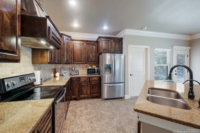 a kitchen with stainless steel appliances granite countertop a refrigerator a stove top oven a sink and dishwasher
