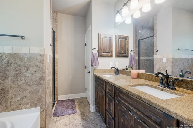 a bathroom with a granite countertop sink a large mirror and a bathtub